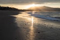 Direct golden sunset`s sunlight on a scenic sandy beach in hendaye in dramatic cloudy atmosphere, basque country, france Royalty Free Stock Photo