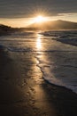 Direct golden sunset`s sunlight on a scenic sandy beach in hendaye in dramatic cloudy atmosphere, basque country, france Royalty Free Stock Photo