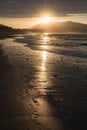 Direct golden sunset`s sunlight on a scenic sandy beach in hendaye in dramatic cloudy atmosphere, basque country, france Royalty Free Stock Photo