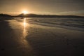 Direct golden sunset`s sunlight on a scenic sandy beach in hendaye in dramatic cloudy atmosphere, basque country, france Royalty Free Stock Photo