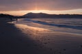 Direct golden sunset`s sunlight on a scenic sandy beach in hendaye in dramatic cloudy atmosphere, basque country, france Royalty Free Stock Photo