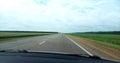 Direct road along green fields Royalty Free Stock Photo