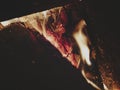 Direct view into fireplace with focus on glowing embers, blurred charred log on right for text space, Royalty Free Stock Photo