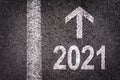 2021 and a direction arrow written on an asphalt road background urban new year greeting card Royalty Free Stock Photo