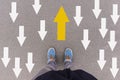 Direction arrows on asphalt ground, feet and shoes on floor Royalty Free Stock Photo