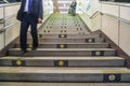 Direction arrows on steps on Tokyo subway with commuters Royalty Free Stock Photo