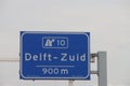 Direction sign in blue and white heading Delft Zuid on motorway A13
