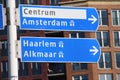 Direction sign heading to Amsterdam, Haarlem and Alkmaar in blue and White in th Netherlands