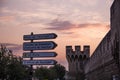 Direction signs with the background of the city walls of Avignon, France