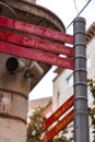 Direction signs at the Carrer de l`Argenteria, a commercial street in the old town of Girona, Spain