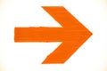 Directional orange arrow manually painted on wooden signboard