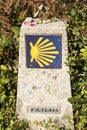 Directional signs on saint james way. Scallop shell and yellow arrow with blue background on a wall. Camino de santiago Royalty Free Stock Photo