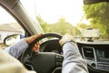 Car interior with male driver sitting behind the wheel, soft sunset light. Luxurious vehicle dashboard and electronics.