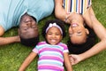 Directly above portrait of smiling african american family lying together on grass at garden Royalty Free Stock Photo