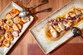 Directly above of a restaurant table with plates of Grilled squid and octopus with olive oil.