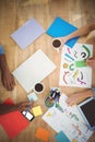 Directly above shot of cropped hands working at desk