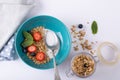 Directly above shot of granola with berry fruits, herbs and milk in bowl with spoon on table Royalty Free Stock Photo