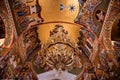 Directly below a golden chandelier and wall paintings inside Agios Gerasimos monastery