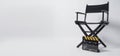 Director chair with black and yellow clapper board or movie slate on white background.it is used in video production and film
