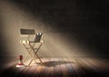 Director`s chair with clapper board and megaphone in dark room scene with spotlight light Royalty Free Stock Photo