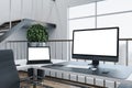 Director`s workspace with laptop and computer monitor with blank white screen Royalty Free Stock Photo