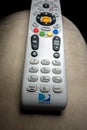 DirecTV remote shot close-up on armchair with black background. Royalty Free Stock Photo
