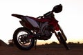 Dirt, bike and sunset in desert for action danger competition, fast race or speed training. Off road, motorcycle and Royalty Free Stock Photo