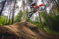 dirt biker soaring over a small hill in a forest