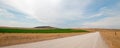 Dirt country road next to uncut Alfalfa field in Montana USA Royalty Free Stock Photo