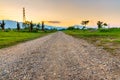 Dirt and gravel country road through the field in countryside of Thailand Royalty Free Stock Photo
