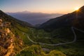 Dirt mountain road leading to high mountain pass in Italy Colle delle Finestre. Expasive view at sunset, colorful dramatic sky, Royalty Free Stock Photo