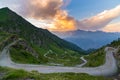 Dirt mountain road leading to high mountain pass in Italy Colle delle Finestre. Expasive view at sunset, colorful dramatic sky, Royalty Free Stock Photo