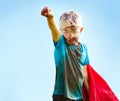 Dirt, mud and portrait of child with superhero costume, fist and confidence playing outside confident on blue background Royalty Free Stock Photo