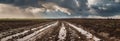 Dirt mud road and puddles on a plowed field after rain in bad weather. Agricultural field. Banner slider horizontal Royalty Free Stock Photo