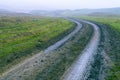 dirt muddy road wet Puddle countryside autumn fall green grass steppe after rain Tire tracks beautiful landscape Moldova Royalty Free Stock Photo