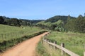 Dirt road that cuts through two pastures in the rural area of a small town