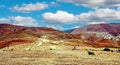 Dirt road through dry arid barren desert valley with colorful mountain range - Cordillera Copiapo, Chile