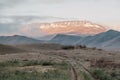 dirt road in field going into mountains. Dawn in autumn field. Hills in morning haze. Grass covered with autumn Royalty Free Stock Photo