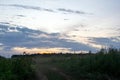 Dirt road through the field late in the evening Royalty Free Stock Photo
