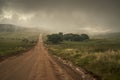 dirt road that goes away towards the cloudy mountains Royalty Free Stock Photo