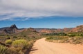 Dirt road leading over high mountain pass in daytime Royalty Free Stock Photo