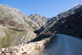 Dirt road leading over high mountain pass in daytime Royalty Free Stock Photo