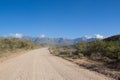 Dirt road leading over high mountain pass in daytime Royalty Free Stock Photo