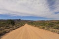 Dirt road leading over mountain pass in daytime Royalty Free Stock Photo