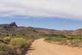 Dirt road leading over mountain pass in daytime Royalty Free Stock Photo