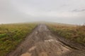 Dirt road leading to the top of the hill, thick fog and clouds Royalty Free Stock Photo