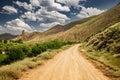 dirt road in middle of a desert area in the mountains. Beautiful and picturesque landscape Royalty Free Stock Photo