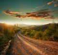 Dirt road in mountains at sunset dramatic sky background Royalty Free Stock Photo