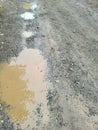 Dirt road with mud puddles after it rain Royalty Free Stock Photo