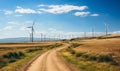Dirt Road Passing Through Field With Windmills in Background Royalty Free Stock Photo